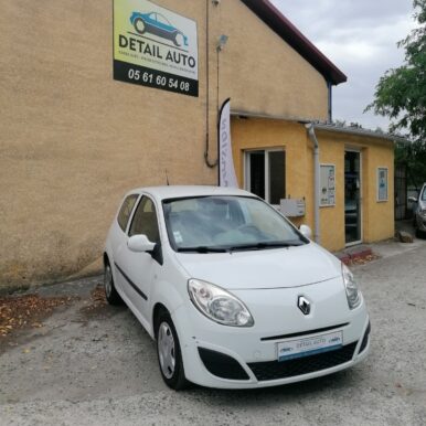 Renault Twingo blanche stationnée devant l'enseigne Detail Auto, casse et vente de voitures d'occasion à Pamiers.