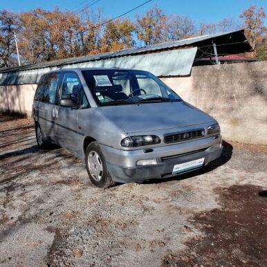Lancia Zeta grise garée devant un mur, avec une affiche À Vendre sur le pare-brise.