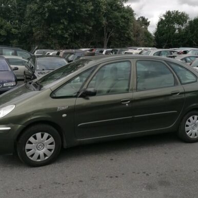 Citroën Xsara Picasso vert olive stationnée, badge Picasso visible sur l'aile avant, monospace compact.