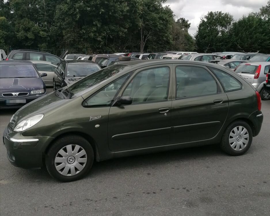 Citroën Xsara Picasso vert olive stationnée, badge Picasso visible sur l'aile avant, monospace compact.