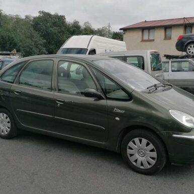 Citroën Xsara Picasso vert foncé avec inscription Picasso sur la porte, garée sur un parking.