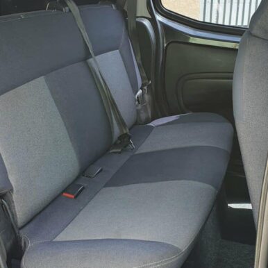 Siège arrière de voiture en tissu bicolore gris et bleu avec ceinture de sécurité installée.